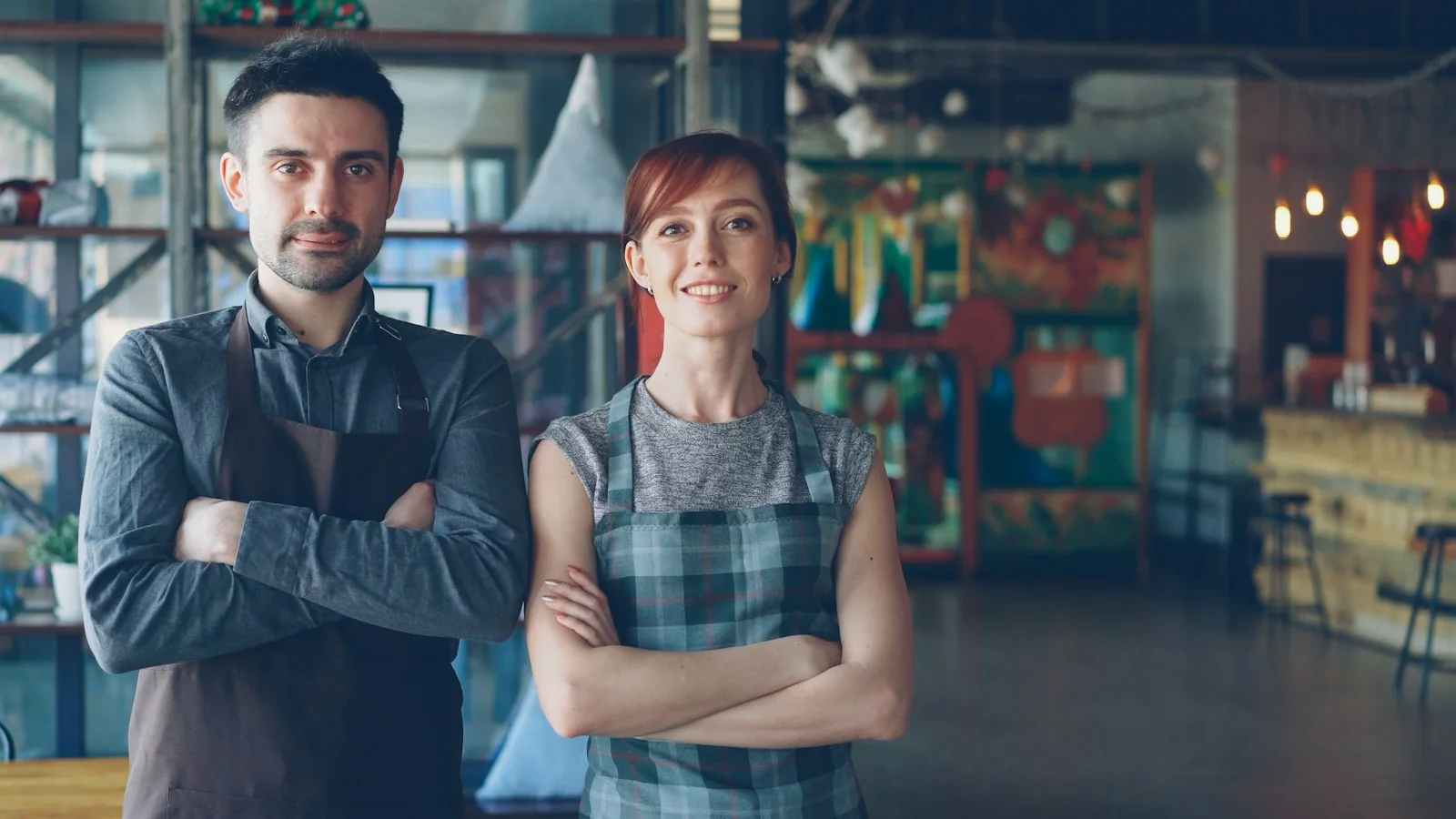 Dos propietarios de una cafetería sonríen en su establecimiento